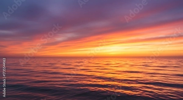 Fototapeta Vibrant sunset sky over calm ocean water with colorful reflections