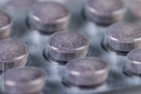 Fototapeta cylindrical purple tablets made from natural ingredients packed in a blister , whole purple tablets packed in a plastic blister with the addition of blueberry extract and other ingredients