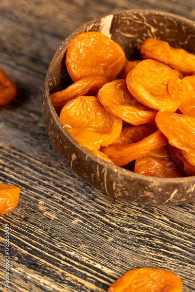 Fototapeta dried apricots made from ripe apricots in a coconut shell plate, dried apricots in a bowl made from natural materials