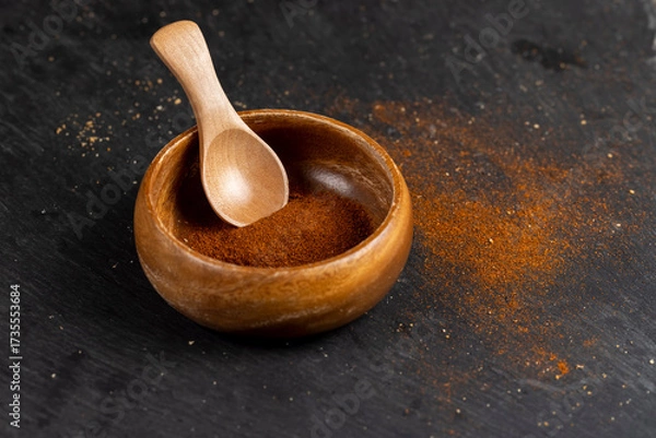 Fototapeta wooden spoon filled with spices from dried and ground sweet pepper, aromatic spices from dried red pepper