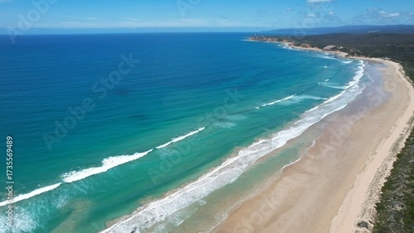Obraz Clean ocean waves breaking on a white sand beach with turquoise emerald colored water