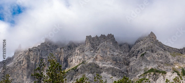 Obraz Alpine mountain peaks emerging above a drifting cloud layer