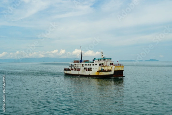 Obraz Ferry and Ferry pier near Koh Phangan island in Thailand. The rear of Ferries transport passengers. The beautiful scenery turquoise sea. Big ferry ship with Thai flag turning at the sea and sails.