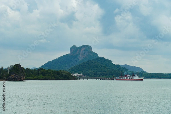 Obraz Ferry and Ferry pier near Koh Phangan island in Thailand. The rear of Ferries transport passengers. The beautiful scenery turquoise sea. Big ferry ship with Thai flag turning at the sea and sails.