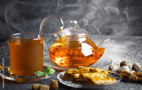 Fototapeta Tea in a cup on a metallic background in a composition with a cookware