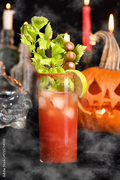 Fototapeta Bloody Mary cocktail. Tomato juice and vodka, garnished with celery stalk, lime and olives. Halloween party ideas.  