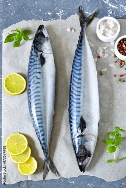 Fototapeta Fresh, raw mackerel with lemon and spices on a concrete background