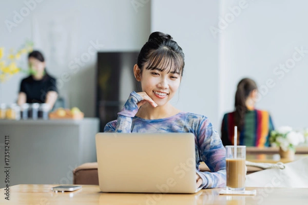 Fototapeta カフェで仕事をするフリーランスの若い女性