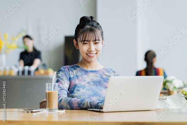 Fototapeta カフェで仕事をするフリーランスの若い女性