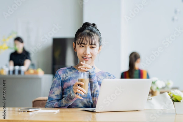 Fototapeta カフェで仕事をするフリーランスの若い女性