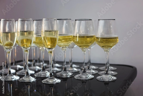 Fototapeta Elegant glassware lined up with sparkling beverage for a festive celebration in bright setting