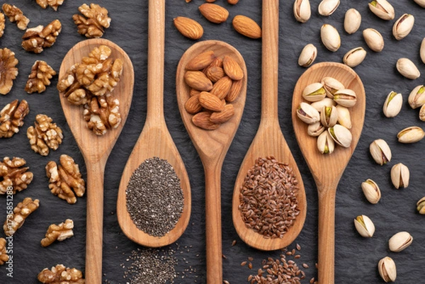 Fototapeta Wooden spoons with nuts and seeds that lower high cholesterol 