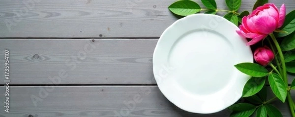 Fototapeta Empty white plate, green peony leaves, rustic gray wood background Top view , texture, minimal