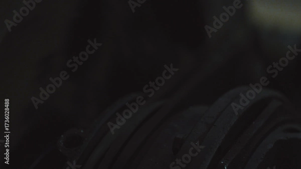 Fototapeta Dark coiled rubber bands forming an abstract, repetitive geometric texture industrial close up with soft diffused lighting, strong contrast, worn synthetic surfaces and subtle shadows