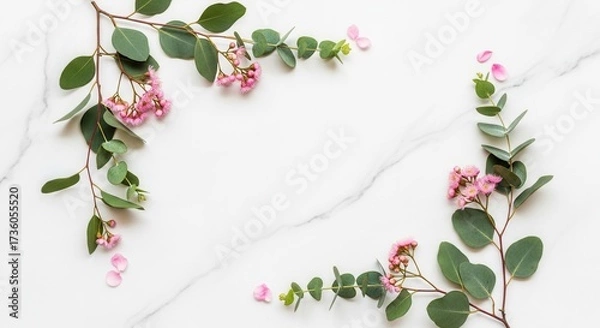 Fototapeta Flowering eucalyptus branches with pink blossoms and petals frame a white marble surface with subtle gray veining