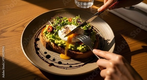Fototapeta Enjoying a Healthy Breakfast of Avocado Toast with a Poached Egg.