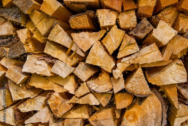 Fototapeta Stacked firewood logs arranged in a rustic pattern showcasing natural textures and warm tones for cozy ambiance