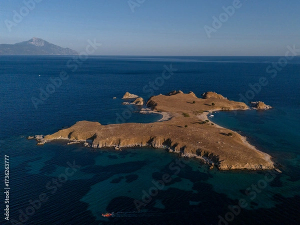 Fototapeta Rocky Island and Boat in Deep Blue Coastal Waters Near Athos, Greece