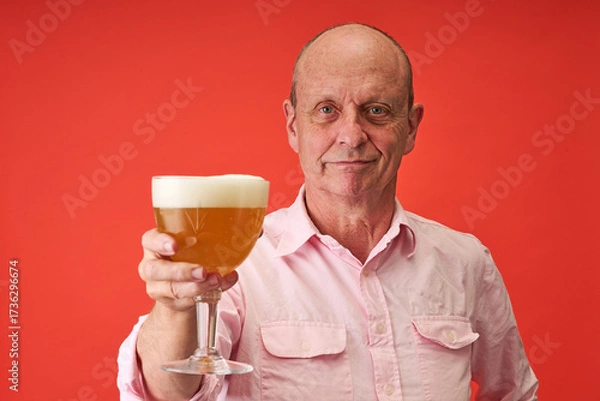 Fototapeta Closeup portrait of a elderly man in studio drinking a trappist beer
