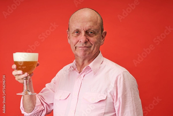 Fototapeta Closeup portrait of a elderly man in studio drinking a trappist beer