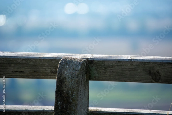 Fototapeta Close-up of a wooden fence post with blurred landscape