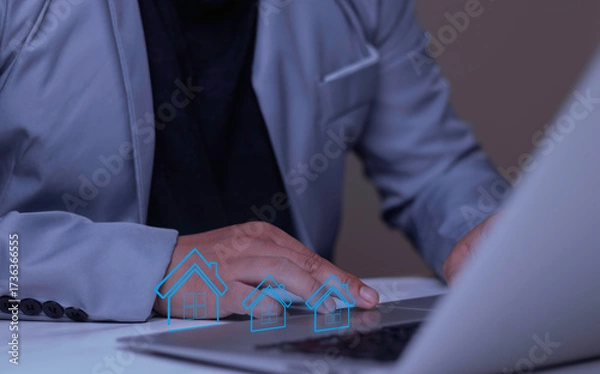 Fototapeta Work from home concept. A businessman uses a laptop in his home office to manage an online business. Virtual house icons symbolize remote work and flexible modern jobs.
