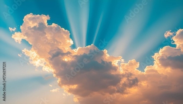 Fototapeta Golden sun rays burst through fluffy, warm-toned clouds against a vibrant blue sky, creating a hopeful and majestic scene.