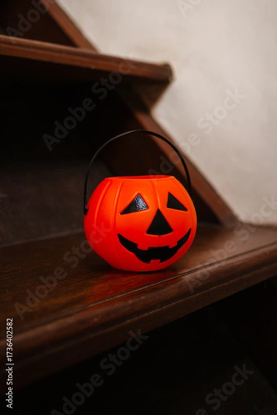 Fototapeta Pumpkin lantern on wooden stairs in the house. Concept of decorations and preparation for Halloween