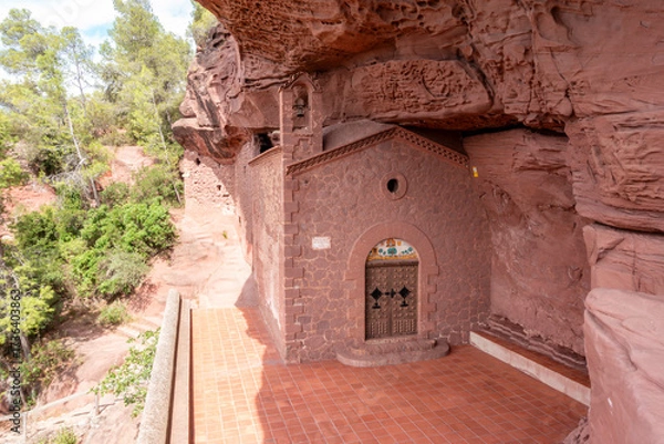 Fototapeta The unique Hermitage of Sant Gregori, a 20th-century chapel built of red sandstone inside a cave near Falset, Catalonia