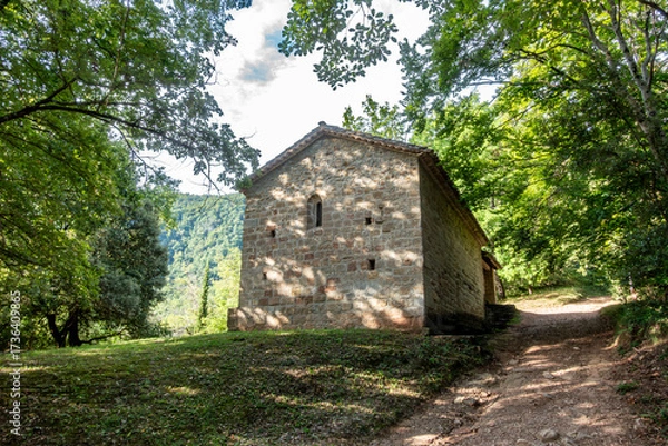 Fototapeta The ancient Romanesque hermitage of Sant Martí del Corb nestled in a forest path in Les Preses. Catalonia, Spain.