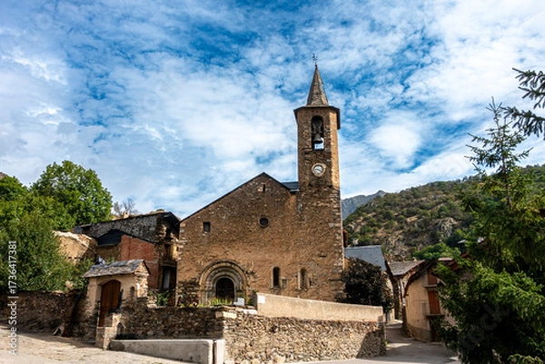 Fototapeta A picturesque view of the ancient Romanesque church of Sant Lliser d'Alós d'Isil, nestled in its traditional mountain village in the Spanish Pyrenees. Catalonia