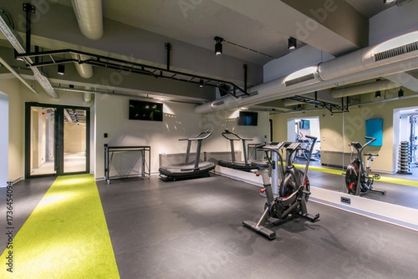 Fototapeta Modern gym with treadmills and exercise bikes