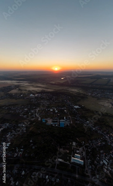 Fototapeta Sun shining on horizon above countryside with fields and villages