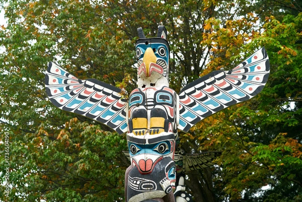 Fototapeta Stanley Park Totem in Autumn Leaves. Stanley Park totem pole with autumn leaves, Vancouver, British Columbia, Canada.
