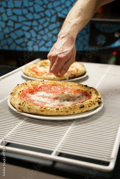 Obraz Chef sprinkling cheese over traditional pizza