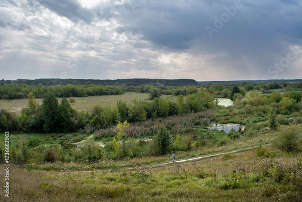 Fototapeta Scenic rural landscape with meadows, river and cloudy sky