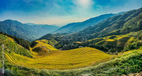Fototapeta  Scenic view of Longji Rice Terraces in Guangxi, China, with golden fields and morning mist enveloping distant hills