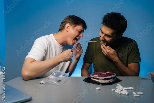 Fototapeta Young adult male consuming cake, surrounded by medication and alcohol bottles, depicting risky recreational behavior and potential substance dependency. Concept of party with substance abuse.