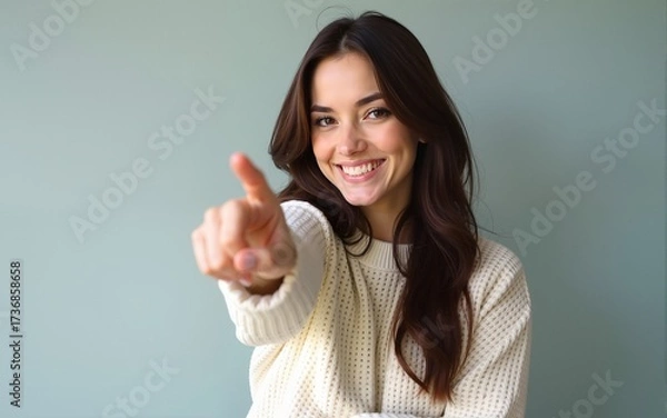 Fototapeta Young brunette woman wearing casual winter sweater smiling and looking at the camera pointing with two hands and fingers to the side. High quality