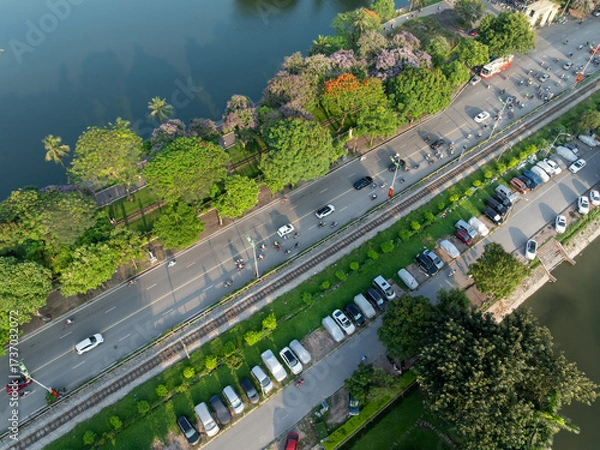 Fototapeta Overhead view of Le Duan street, parked cars, and lakeside promenade in Hanoi.