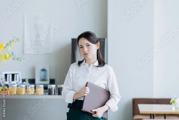Fototapeta 飲食店で悩む若い女性のスタッフ