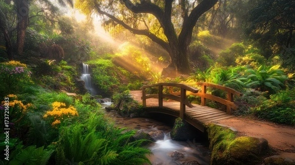 Fototapeta Sunlight streams through a misty forest garden, illuminating a small wooden bridge over a babbling brook.  Vibrant flowers and ferns surround the scene