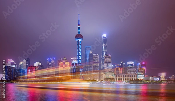 Fototapeta Shanghai colorful skyline with motion speed light of passing ferry in the foreground at night - Shanghai, China