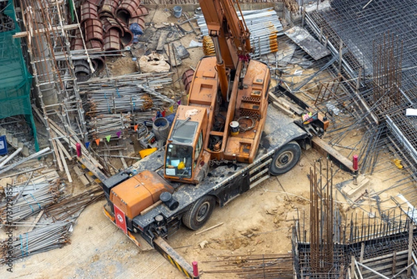 Fototapeta A view of a construction site including a crane, surrounded by building materials