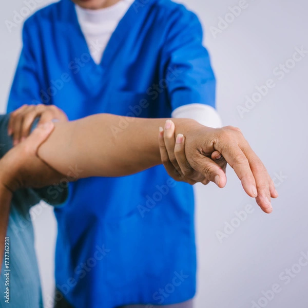Obraz An Asian female nurse provides caring home care to an elderly woman, assisting with arm movement exercises, physical therapy,and rehabilitation to improve joint function, strength,overall well-being