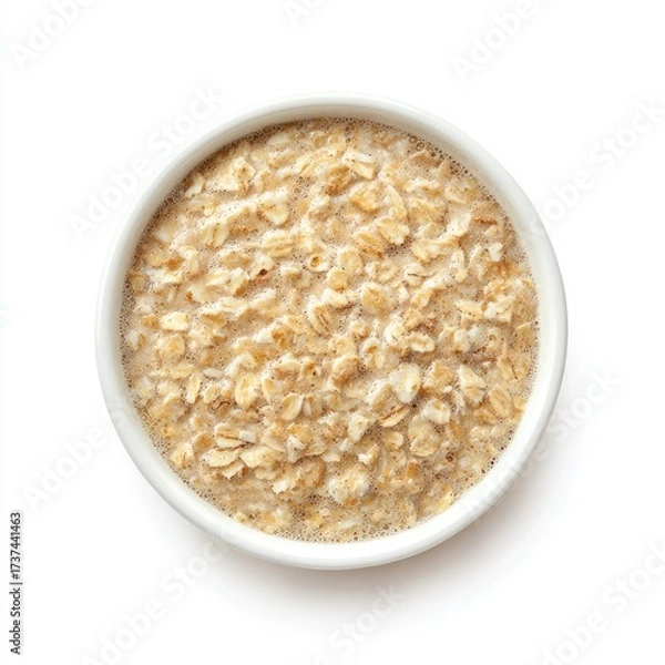 Fototapeta Creamy oatmeal in a small white bowl, viewed from directly above on a white background