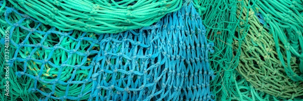 Fototapeta Panorama of pile of colourful fishing nets on a quayside for use as a background texture