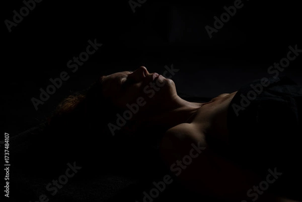 Fototapeta Woman receiving relaxing shoulder massage in dimly lit spa environment