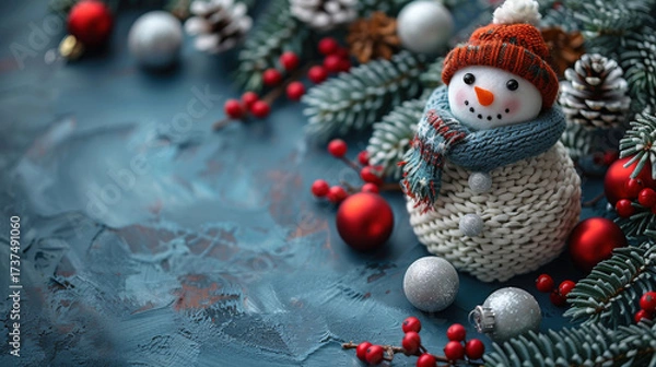 Fototapeta Christmas card. Cheerful snowman on festive blue background with fir branches, cones and Christmas toys. New Year postcard. Copy space.