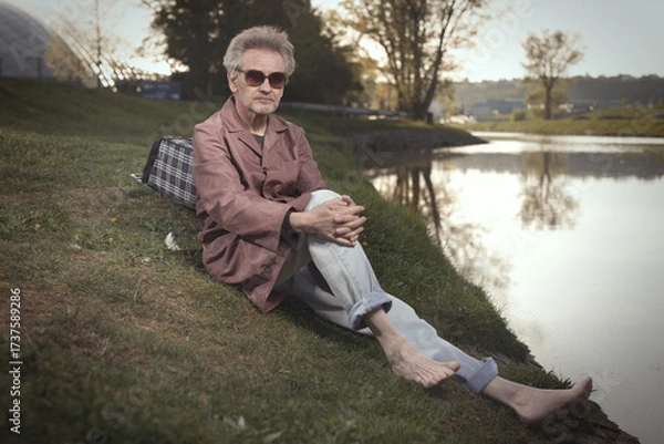 Fototapeta Senior citizen spending time alone in spring park with cart